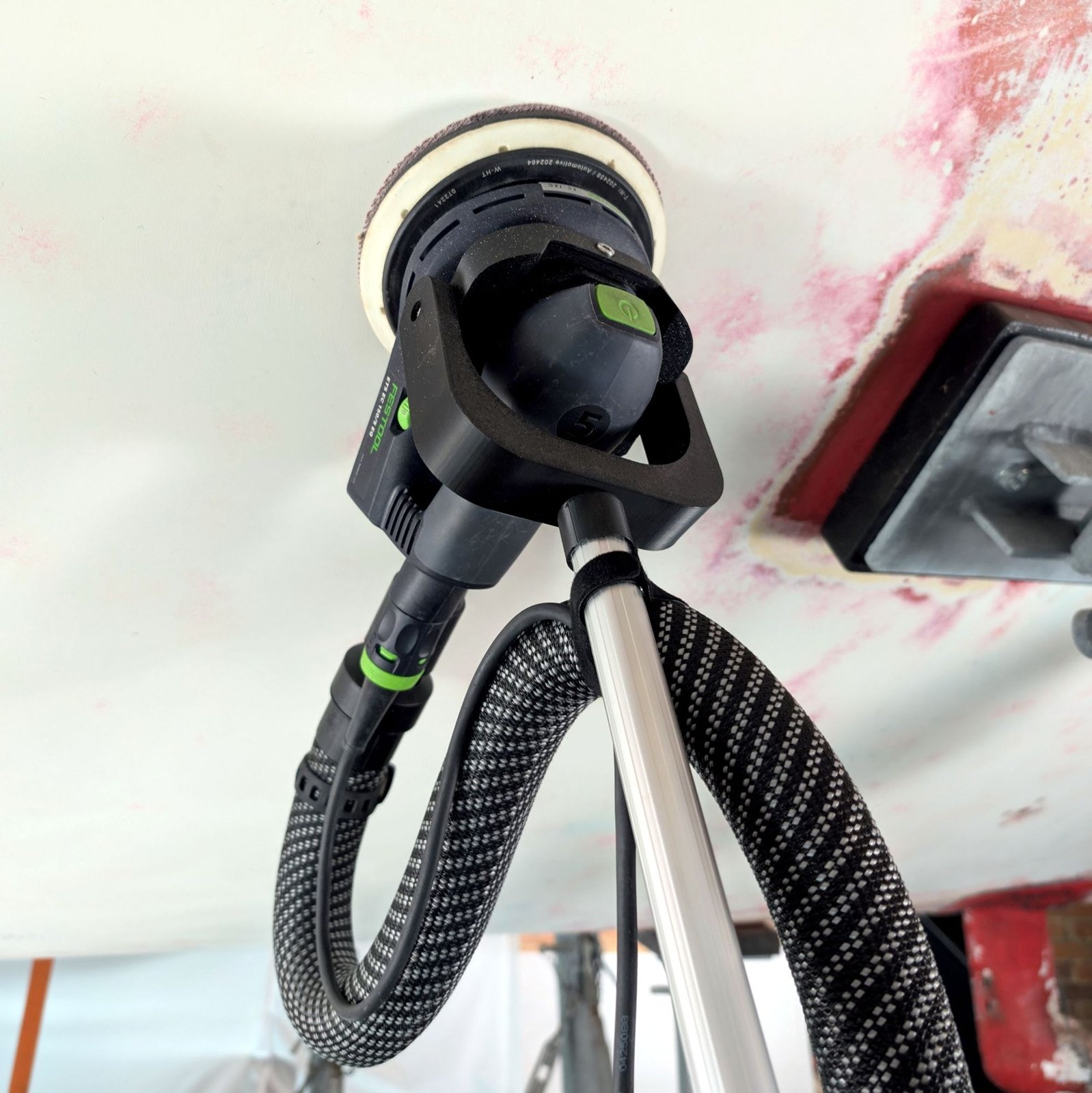 Festool ETS EC 150/5 mit Schleifunterstützung beim Schleifen unter dem Rumpf, Schlauch an der Stange befestigt